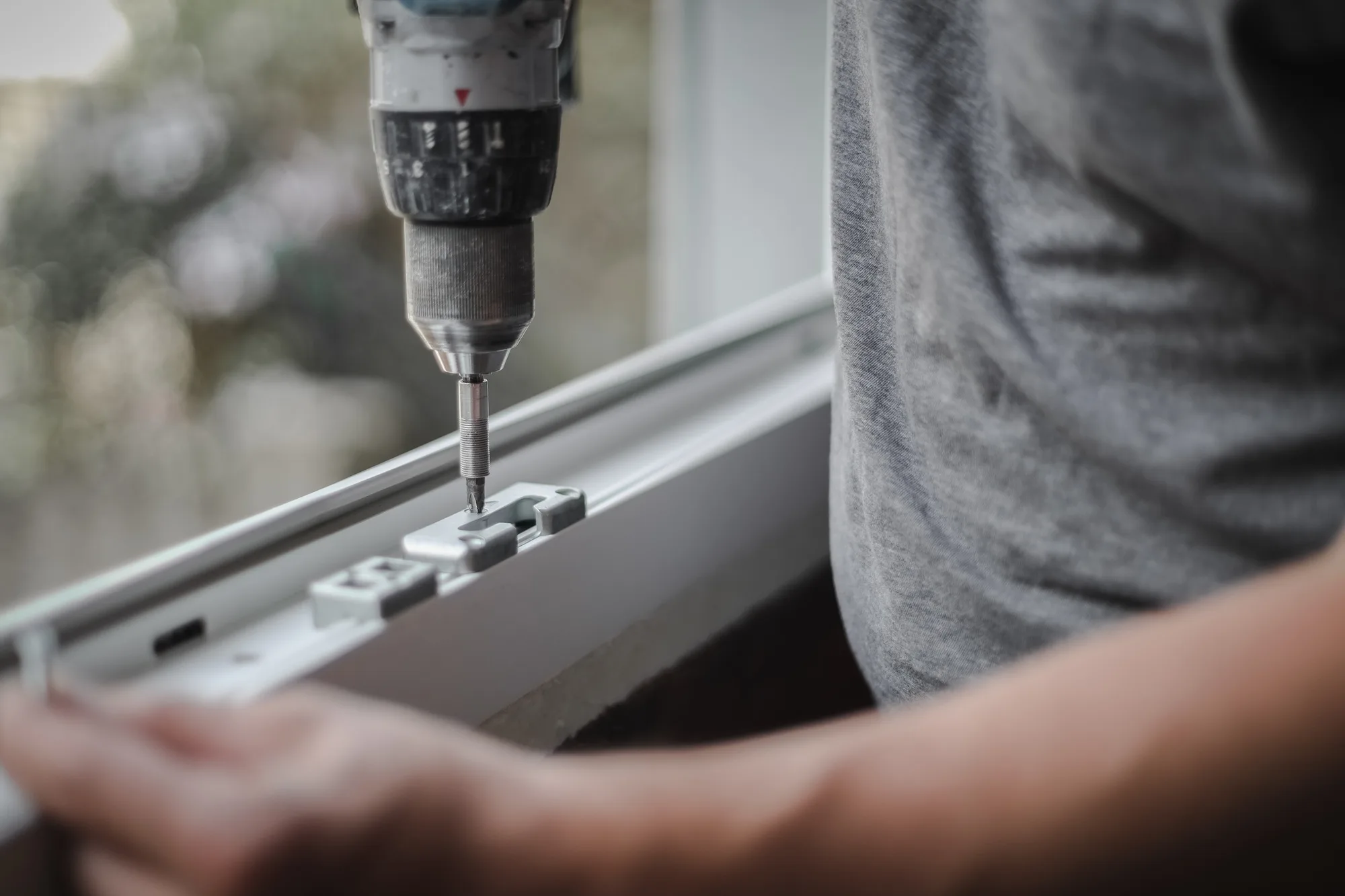 Caucasian man installs fittings for a window frame.